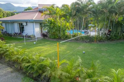 a house with a yard with palm trees at Arenal Family Home - Families & Friends Gateway in Fortuna