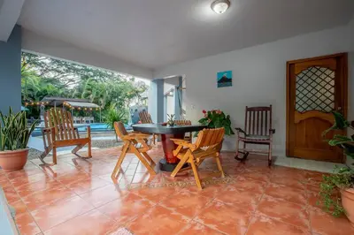 a dining room with a table and chairs and a patio at Arenal Family Home - Families & Friends Gateway in Fortuna
