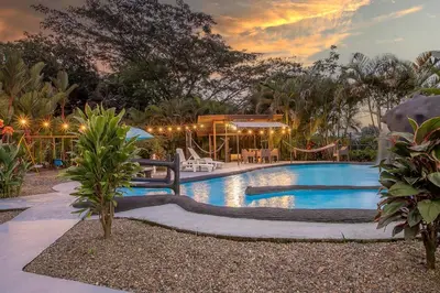 a swimming pool in a yard with a house at Arenal Family Home - Families & Friends Gateway in Fortuna