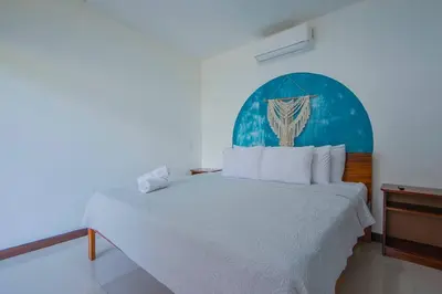 a bedroom with a large bed with a blue headboard at Villa Arthur La Fortuna in Fortuna
