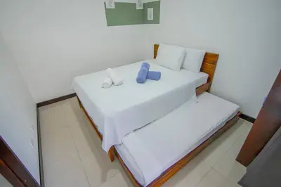 a bedroom with two beds with white sheets and blue pillows at Villa Arthur La Fortuna in Fortuna