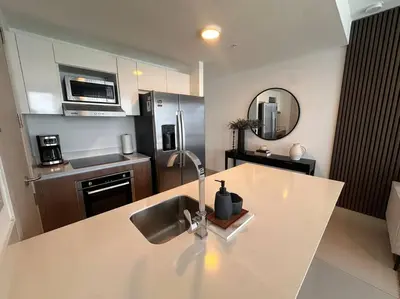 a kitchen with a counter with a sink and a refrigerator at Exclusivo Apartamento en Sabana in Uruca