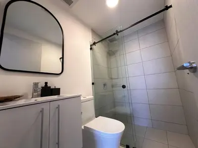 a bathroom with a shower and a toilet and a mirror at Exclusivo Apartamento en Sabana in Uruca