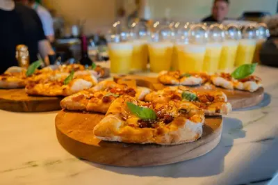 a group of pizzas on plates on a table with drinks at Exclusivo Apartamento en Sabana in Uruca