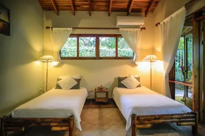 two beds in a room with two lamps at Villas Santa Teresa in Santa Teresa Beach