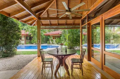 a patio with a table and chairs and a ceiling fan at Villas Santa Teresa in Santa Teresa Beach