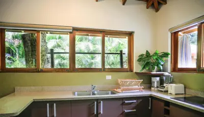 a kitchen with a sink and two windows at Villas Santa Teresa in Santa Teresa Beach
