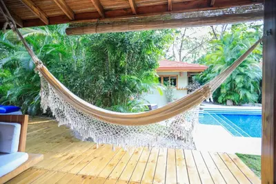 a hammock on a patio with a pool at Villas Santa Teresa in Santa Teresa Beach