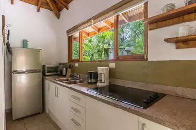 a kitchen with a sink and a refrigerator at Villas Santa Teresa in Santa Teresa Beach