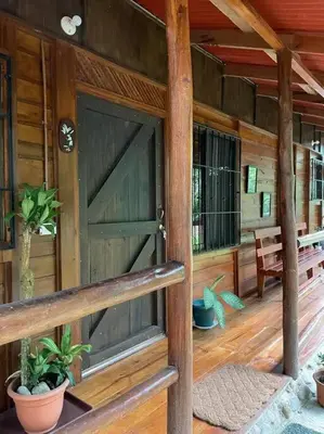 a front door of a wooden house with a porch at Hermosa Cabaña equipada, en medio de zonas verdes in Pedregoso