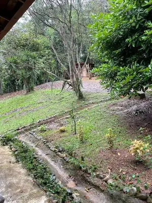 a field of grass with a house in the background at Hermosa Cabaña equipada, en medio de zonas verdes in Pedregoso