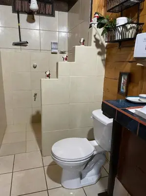 a bathroom with a white toilet and a sink at Hermosa Cabaña equipada, en medio de zonas verdes in Pedregoso