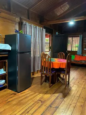 a dining room with a table and a refrigerator at Hermosa Cabaña equipada, en medio de zonas verdes in Pedregoso