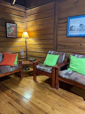 a room with two chairs and a table and a lamp at Hermosa Cabaña equipada, en medio de zonas verdes in Pedregoso