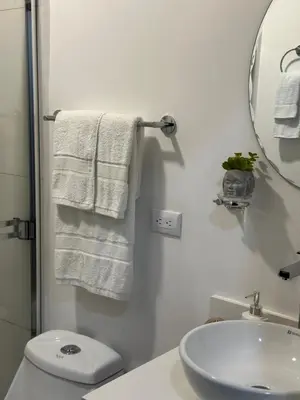 a bathroom with a sink and a toilet and a mirror at Apt 3BR,2BA, 4mi from SJO Airport, Pool,Gated, Gym in Alajuela City