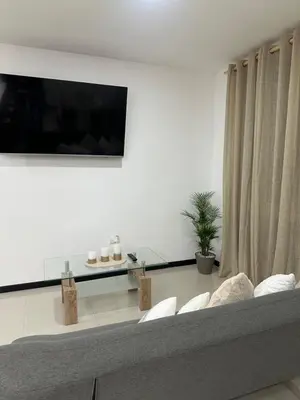 a living room with a couch and a flat screen tv at Apt 3BR,2BA, 4mi from SJO Airport, Pool,Gated, Gym in Alajuela City