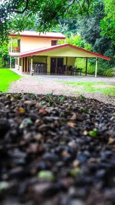 a house with a red roof and a gravel yard at Morada La Gloria in Barbacoas