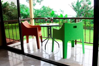 two chairs and a table with wine glasses on a balcony at Morada La Gloria in Barbacoas