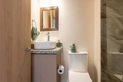 a bathroom with a sink and a toilet and a mirror at Apartamento El Delfín in Playa Danta