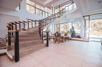 a room with stairs and a table and some windows at Private Beach Mansion Ocean View at Tambor Hills in Tambor