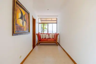a living room with a red chair and a window at Private Beach Mansion Ocean View at Tambor Hills in Tambor