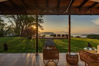 a patio with chairs and a view of a field at Private Beach Mansion Ocean View at Tambor Hills in Tambor