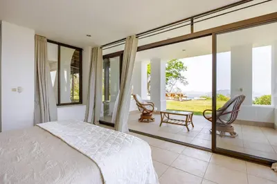 a bedroom with a bed and sliding glass doors at Private Beach Mansion Ocean View at Tambor Hills in Tambor