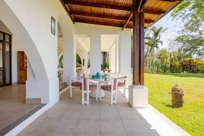 an outdoor dining area of a house with a table and chairs at Private Beach Mansion Ocean View at Tambor Hills in Tambor