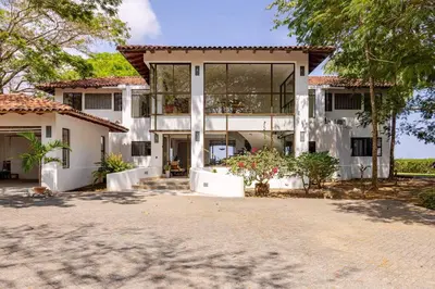 a large white house with a lot of windows at Private Beach Mansion Ocean View at Tambor Hills in Tambor
