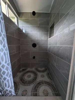 a bathroom with a shower with a tiled floor at Villa Jalapa 