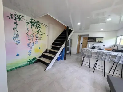 a living room with a staircase and a kitchen at Villa Jalapa 