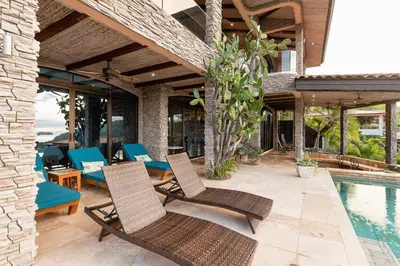 a patio with chairs and a swimming pool at Casa De Los Sueos in Playa Hermosa