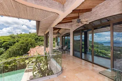 an exterior view of a house with windows and a balcony at Casa De Los Sueos in Playa Hermosa