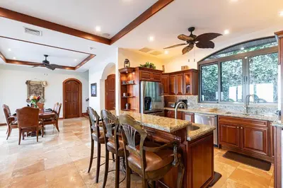a kitchen with a table and chairs and a ceiling fan at Casa De Los Sueos in Playa Hermosa