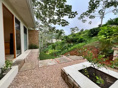 a home with a garden with rocks and trees at Alta Loma in Ojochal