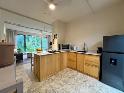 a kitchen with wooden cabinets and a black refrigerator at Alta Loma in Ojochal