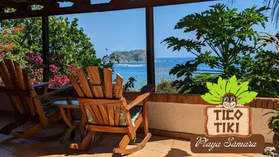 a porch with chairs and a table and a view of the ocean at Tico Tiki Vacation Villa, 5 Bedroom in Sámara