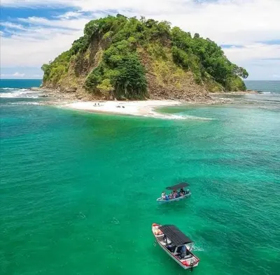two boats in the water next to a small island at Tico Tiki Vacation Villa, 5 Bedroom in Sámara