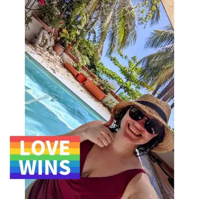 a woman wearing a hat and sunglasses next to a swimming pool at Tico Tiki Vacation Villa, 5 Bedroom in Sámara