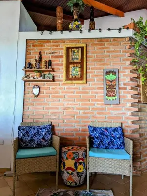 two chairs sitting in front of a brick wall at Tico Tiki Vacation Villa, 3 Bedroom in Sámara