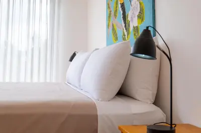 a bedroom with a bed with white pillows and a lamp at Sunrise 42 - 2 Bedroom Ocean View Condo in Tamarindo