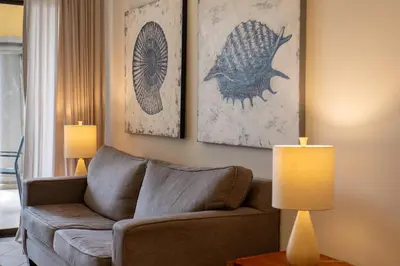 a living room with a couch and two paintings on the wall at Sunrise 42 - 2 Bedroom Ocean View Condo in Tamarindo