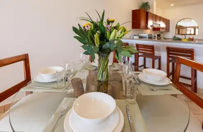 a dining room table with a vase of flowers on it at Sunrise 42 - 2 Bedroom Ocean View Condo in Tamarindo
