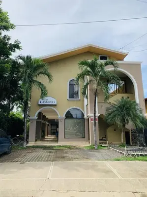 a building with two palm trees in front of it at A6 PL Near the Beach 1bed 1bath private terrace in Tamarindo