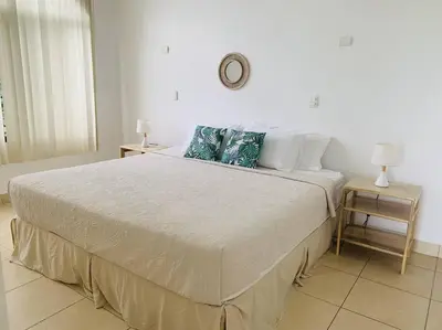 a bedroom with a large bed with two tables at A6 PL Near the Beach 1bed 1bath private terrace in Tamarindo