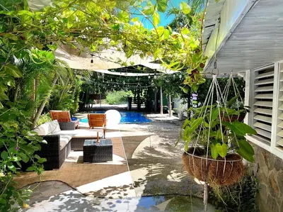 a patio with a swing and some plants at El Reinas by Sugar's Monkey in Playa Grande