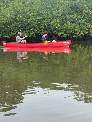 two people in a red canoe on the water at El Reinas by Sugar's Monkey in Playa Grande