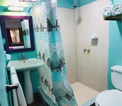 a bathroom with a shower curtain and a sink at El Reinas by Sugar's Monkey in Playa Grande