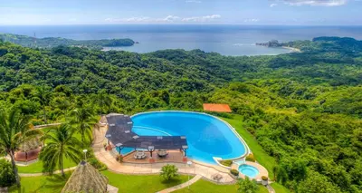 an aerial view of a resort swimming pool and the ocean at Las Ventanas del Mar-Ridge Condo #13 in Santo Domingo