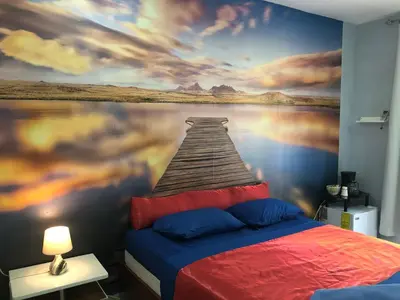 a bedroom with a painting of a pier on the water at Tucan in Coco